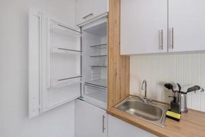 Interior of the small living equipped kitchen in studio apartments in minimalistic style with light color photo