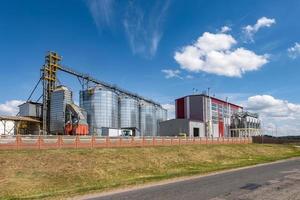 Modern Granary elevator. Silver silos on agro-processing and manufacturing plant for processing drying cleaning and storage of agricultural products, flour, cereals and grain. photo