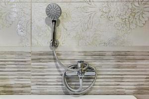 fregadero con grifo de agua en un costoso baño tipo loft. detalle de una cabina de ducha de esquina con accesorio de ducha montado en la pared foto