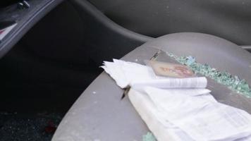 The interior of the car was damaged after the accident. On the seat lies the icon of the amulet of St. Nicholas the Wonderworker close-up and fragments of broken glass. Ukraine, Irpen - May 12, 2022. video