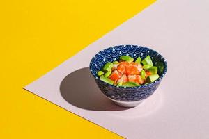 Poke bowl with rice, avocado, edamame beans and smoked salmon. Hard light, deep shadow photo