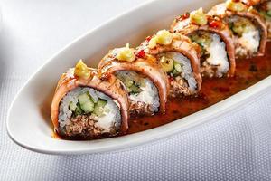 Baked warm sushi rolls with eel, cucumber and smoked salmon photo