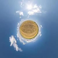 little planet transformation of spherical panorama 360 degrees. Spherical abstract aerial view in field with clear sky and awesome beautiful clouds. Curvature of space. photo