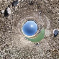 Inversion of little planet transformation of spherical panorama 360 degrees. Spherical abstract aerial view on field with awesome beautiful clouds. Curvature of space. photo