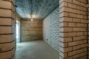 Empty basement room with minimal preparatory repairs. interior with white brick walls photo