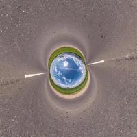 Inversion of blue little planet transformation of spherical panorama 360 degrees. Spherical abstract aerial view on field with awesome beautiful clouds. Curvature of space. photo