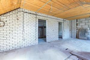 empty interior in house without repair on wooden mansard  floor and brick wall photo