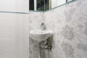 white ceramic washbasin with water tap sink with faucet in expensive bathroom photo