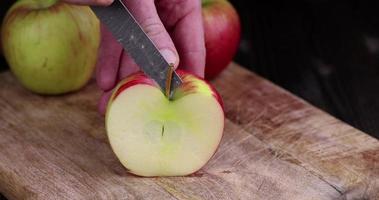 cortar una manzana roja en varios pedazos durante la cocción foto