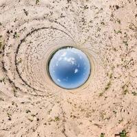 Inversion of blue little planet transformation of spherical panorama 360 degrees. Spherical abstract aerial view on road with awesome beautiful clouds. Curvature of space. photo