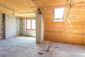 empty interior in house without repair on wooden mansard  floor and brick wall photo