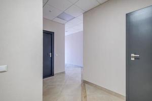largo pasillo blanco vacío en el interior del vestíbulo de entrada de apartamentos modernos, oficina o clínica foto