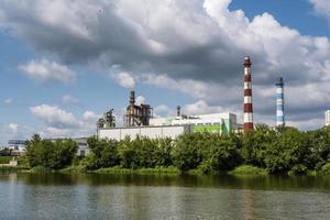 pipes of woodworking enterprise plant sawmill near river. Air pollution concept. Industrial landscape environmental pollution waste of thermal power plant photo