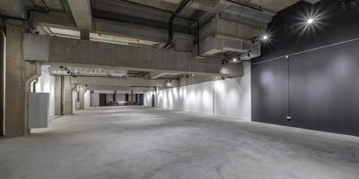 empty interior of large concrete room as warehouse or hangar with spotlights photo