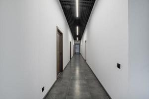 long white empty corridor in interior of entrance hall of modern apartments, office or clinic photo