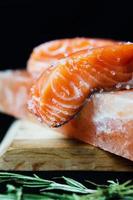 Fresh raw salmon fillet with seasonings and herbs on the block of himalayan salt photo