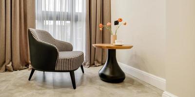 decor elements of the guest room and rest room with a tea table, an armchair and a bouquet of flowers and a cup of coffee photo