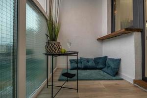 dinner tea table with chairs on the balcony in bright interior photo