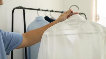 el hombre está eligiendo camisa en el cuarto de ropa en casa. foto