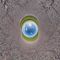 Inversion of little planet transformation of spherical panorama 360 degrees. Spherical abstract aerial view on field with awesome beautiful clouds. Curvature of space. photo