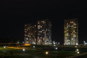 panorama nocturno de luz en las ventanas de un edificio de varios pisos. la vida en una gran ciudad foto