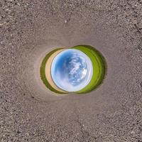 Inversion of blue little planet transformation of spherical panorama 360 degrees. Spherical abstract aerial view on road with awesome beautiful clouds. Curvature of space. photo