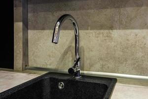 metal water tap sink with faucet in expensive loft kitchen photo