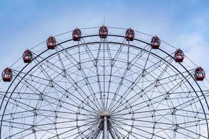 Ferris wheel on blue cloudy sky background photo