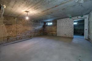 Empty unfurnished basement room with minimal preparatory repairs. interior with white brick walls photo