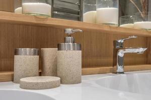 details of corner with water tap sink with faucet with soap and shampoo dispensers in expensive bathroom in rustic eco style photo
