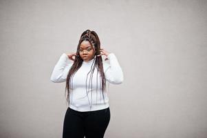 Glamorous african american woman in white turtleneck sweater pose at street. photo