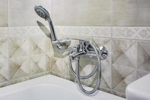 water tap sink with faucet in expensive loft bathroom. detail of a corner shower cabin with wall mount shower attachment photo