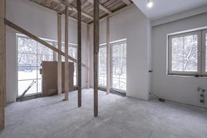 empty white room without repair and furniture with scaffolding photo
