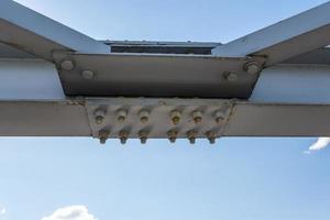 iron steel frame construction of bridge on blue sky background. bridge metal structures, frames, bolts and nuts photo