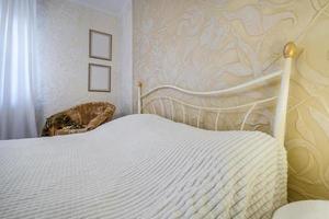 Interior of the modern luxure bedroom with pillows on the bed in studio apartments in light color style photo