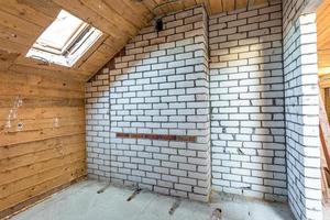 empty interior in house without repair on wooden mansard  floor and brick wall photo