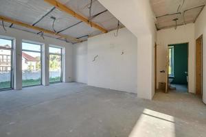 Empty unfurnished room with minimal preparatory repairs. interior with white walls and drywall photo