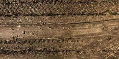 panorama of road from above on surface of gravel road with car tire tracks photo