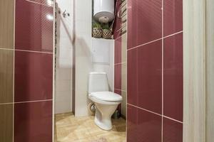 toilet and detail of a corner shower cabin with wall mount shower attachment photo