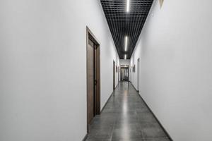 largo pasillo blanco vacío en el interior del vestíbulo de entrada de apartamentos modernos, oficina o clínica foto