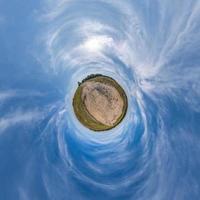tiny planet transformation of spherical panorama 360 degrees. Spherical abstract aerial view in field with clear sky and awesome beautiful clouds. Curvature of space. photo