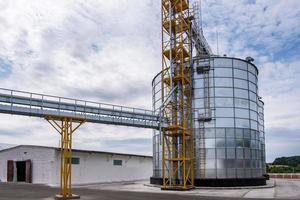 Modern Granary elevator. Silver silos on agro-processing and manufacturing plant for processing drying cleaning and storage of agricultural products, flour, cereals and grain. photo