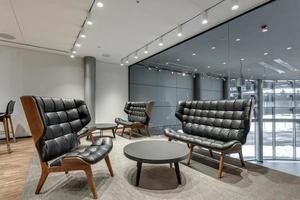 resting lounge place with luxury armchairs in a modern office with glass walls and led lamps photo