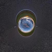 Inversion of blue little planet transformation of spherical panorama 360 degrees. Spherical abstract aerial view on road with awesome beautiful clouds. Curvature of space. photo