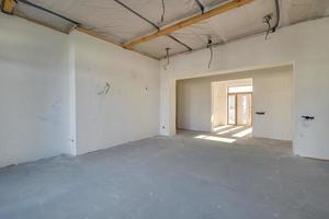 Empty unfurnished room with minimal preparatory repairs. interior with white walls and drywall photo