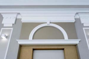 Detail of corner ceiling with intricate crown molding on column with spot light photo