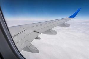 ala de avión desde la ventana del avión con vistas al cielo azul y hermosas nubes foto