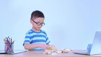 Asian boy playing with a wooden puzzle video