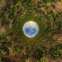 blue sky ball in middle of swirling field. Inversion of tiny planet transformation of spherical panorama 360 degrees. Curvature of space. photo