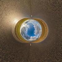 blue sky ball in middle of swirling asphalt road. Inversion of tiny planet transformation of spherical panorama 360 degrees. Curvature of space. photo